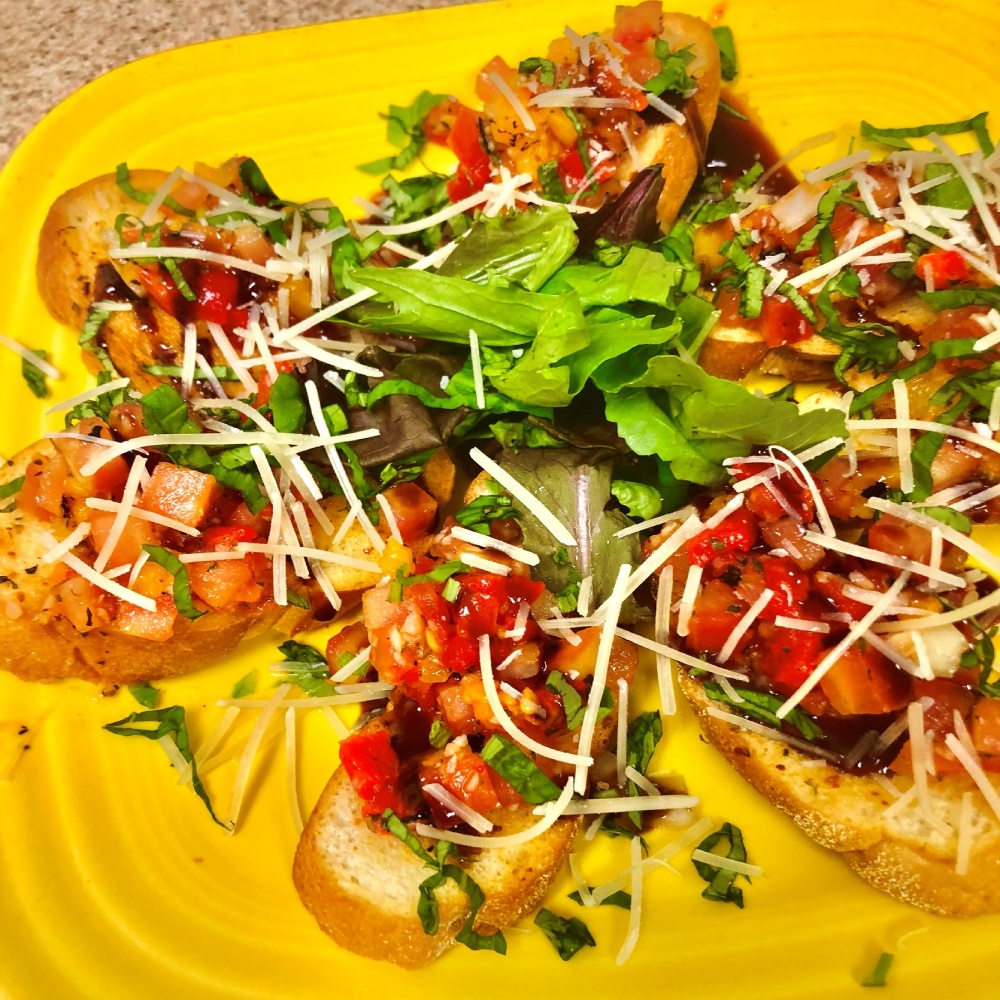 A yellow plate topped with bruschetta.
