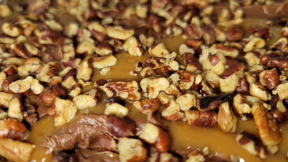 A close up of a dessert with nuts and caramel.