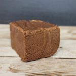 A piece of chocolate fudge sitting on top of a wooden table.