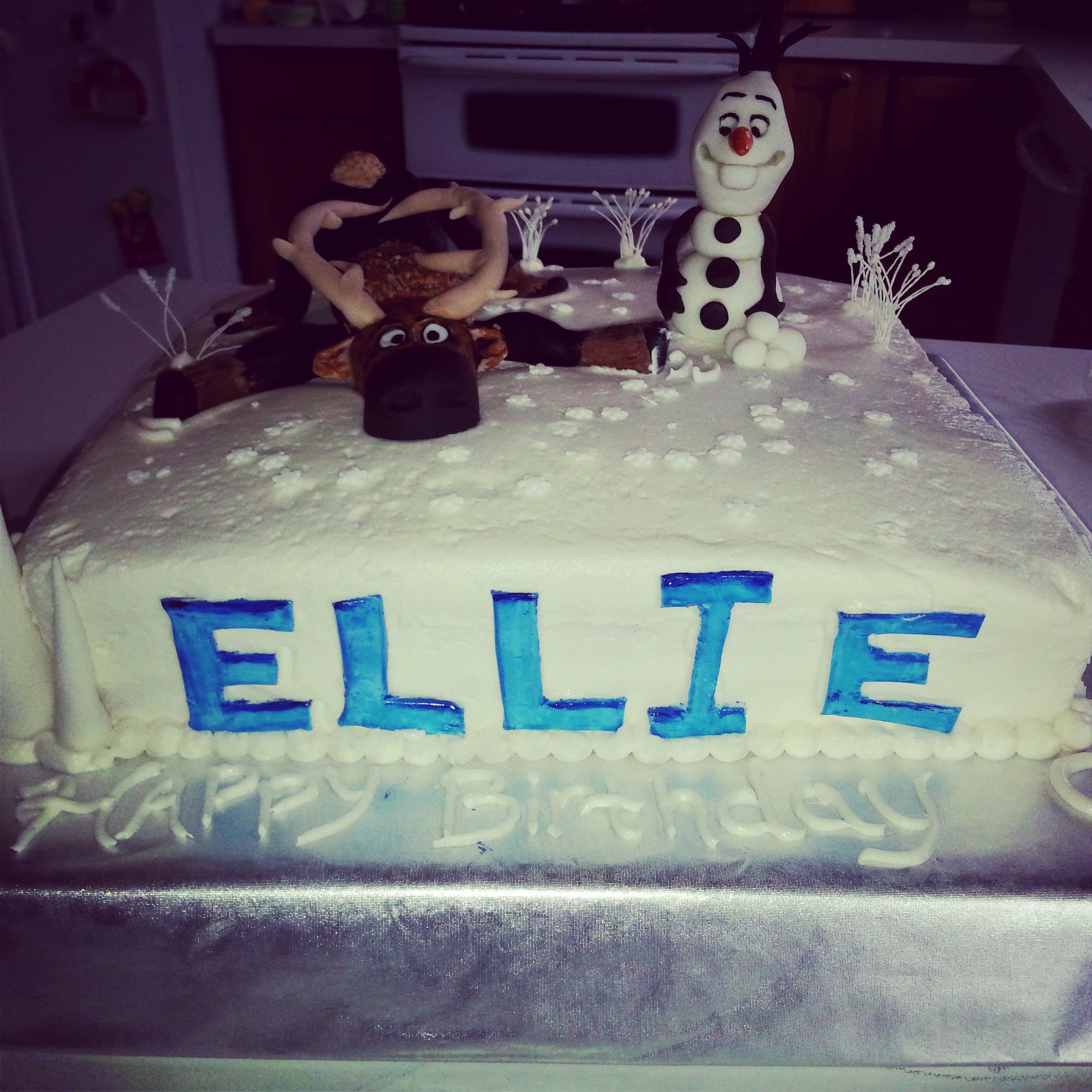 Customfrozen birthday cake with olaf and elsa on it.