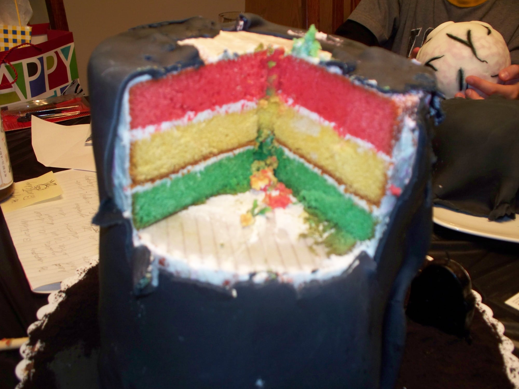 Custom rainbow colored cake with a slice taken out of it. Made by Nan's Nummies