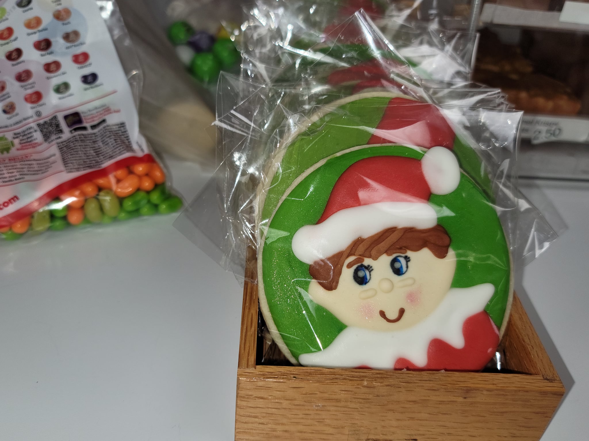 An elf cookie sitting in a wooden box.