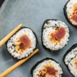 Tuna sushi with chopsticks on a plate.