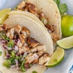 Chicken tacos on a blue and white plate.