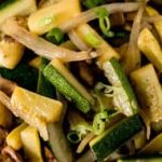 Zucchini and mushroom stir fry in a white bowl.