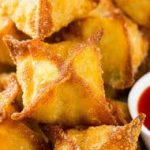 Fried dumplings on a plate with dipping sauce.