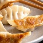 Dumplings on a plate with chopsticks.