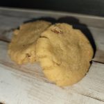 Two cookies sitting on top of a wooden table.
