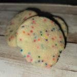 Sprinkled sugar cookies on a wooden table.