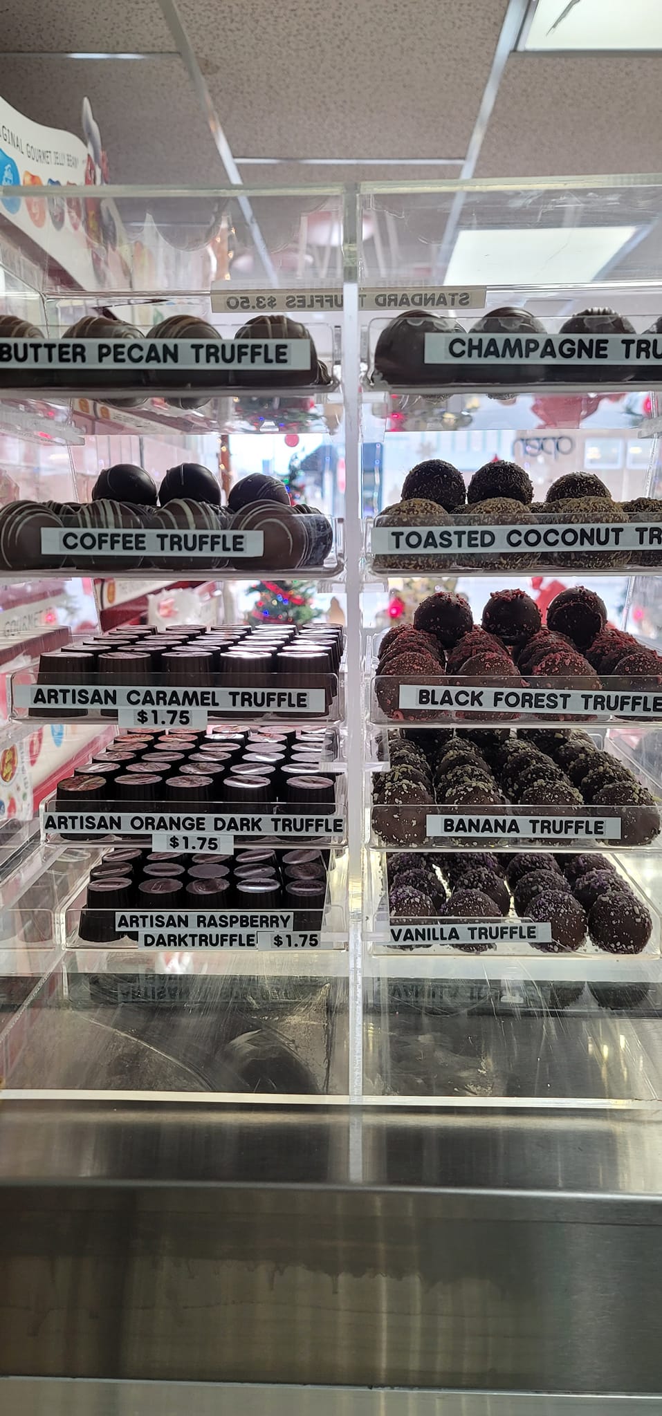 A display case full of chocolate covered donuts.