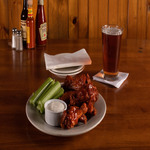 A plate of wings and celery on a wooden table.