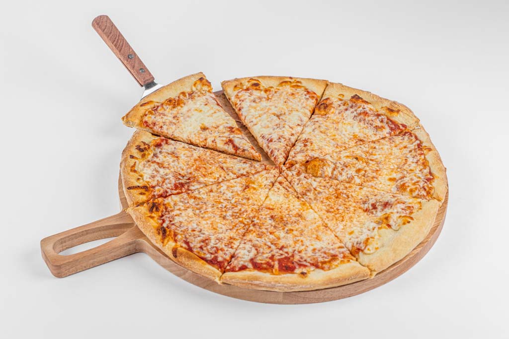 A slice of pizza on a wooden board with a knife.