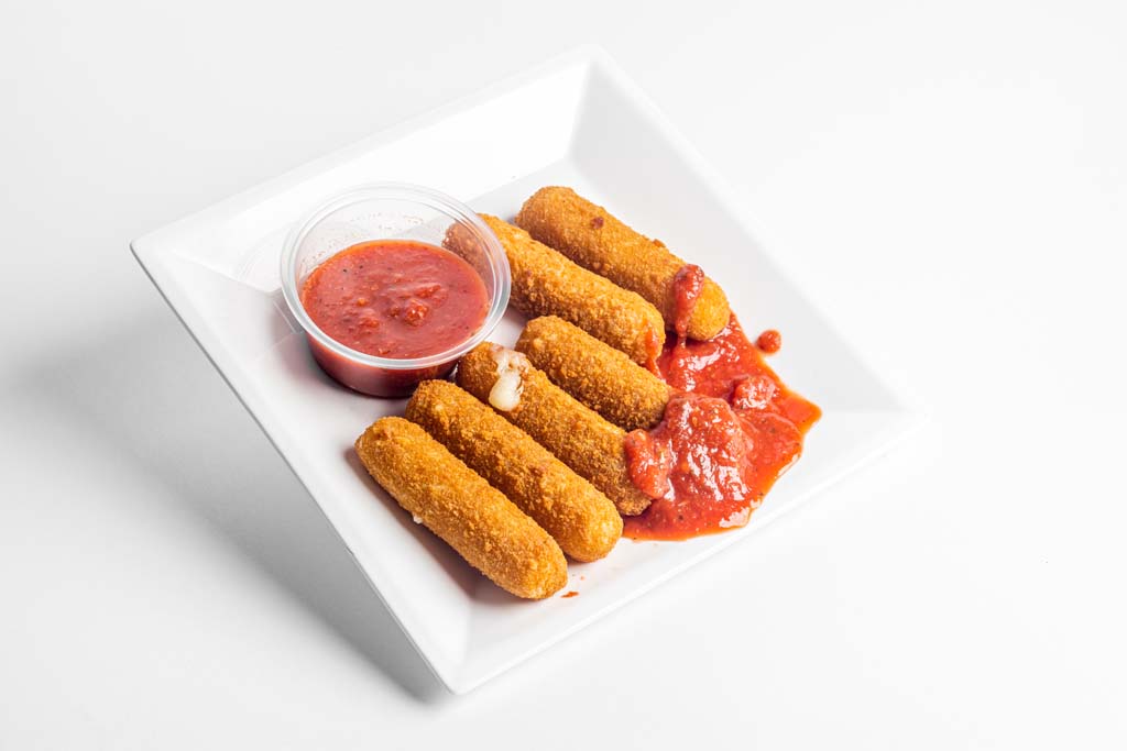 A plate of fried chicken sticks with sauce and ketchup on a white background.