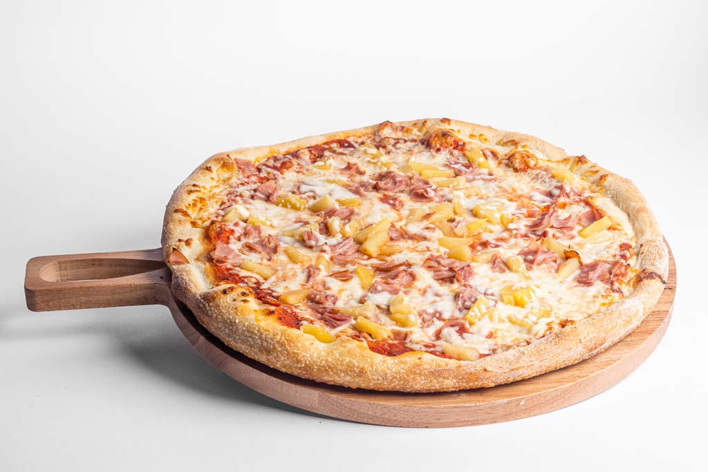 A pizza sitting on a wooden board on a white background.