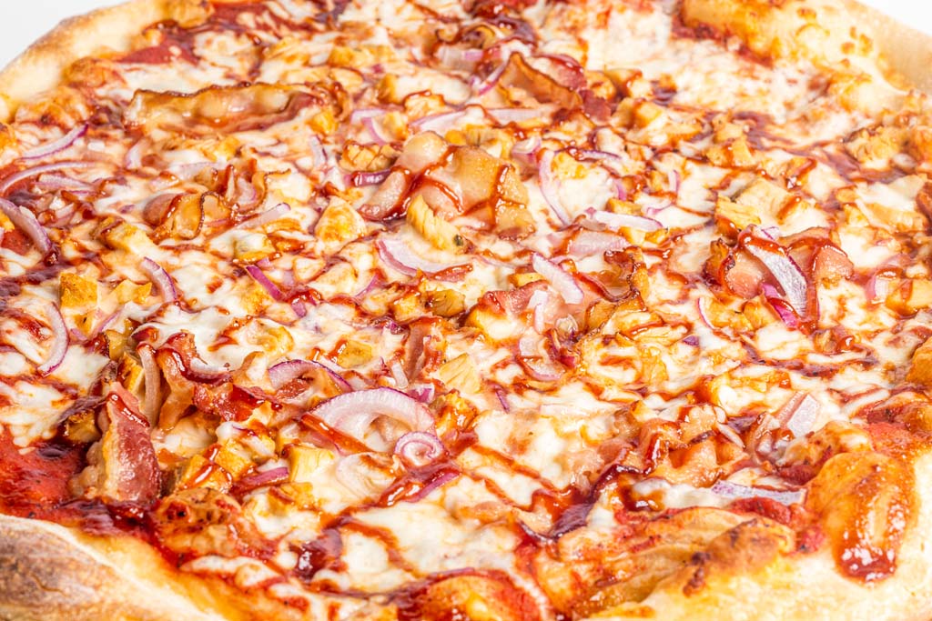 A pizza with sauce and onions on top.