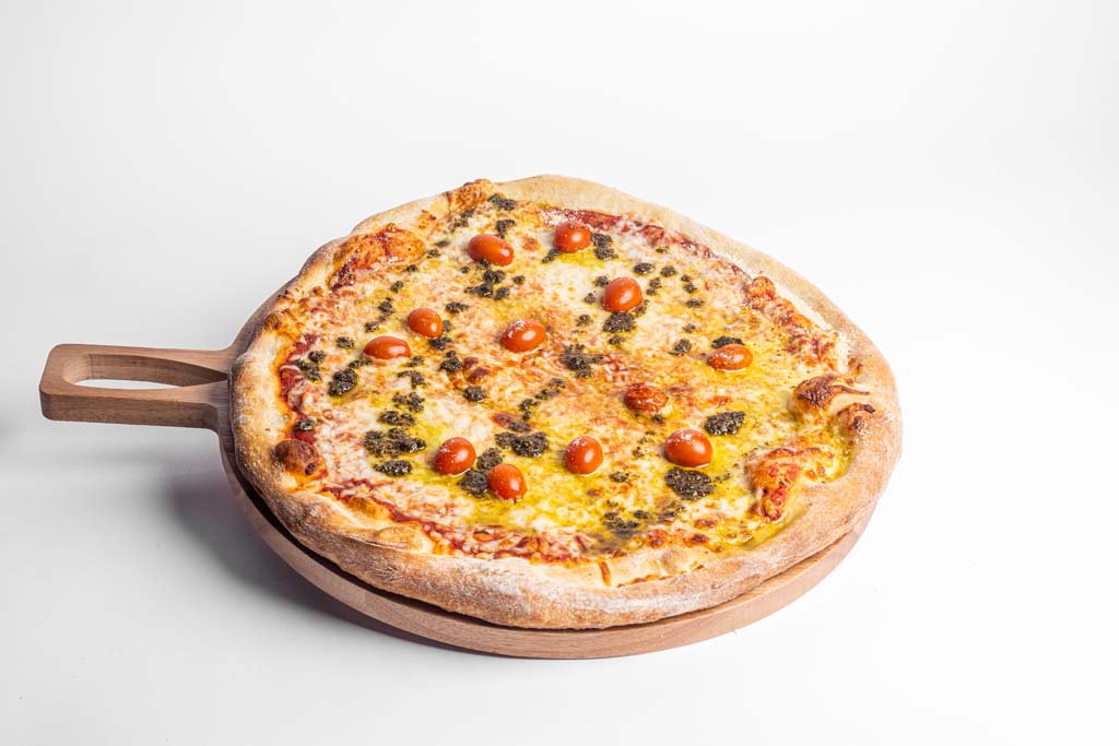 A pizza is sitting on a wooden plate.