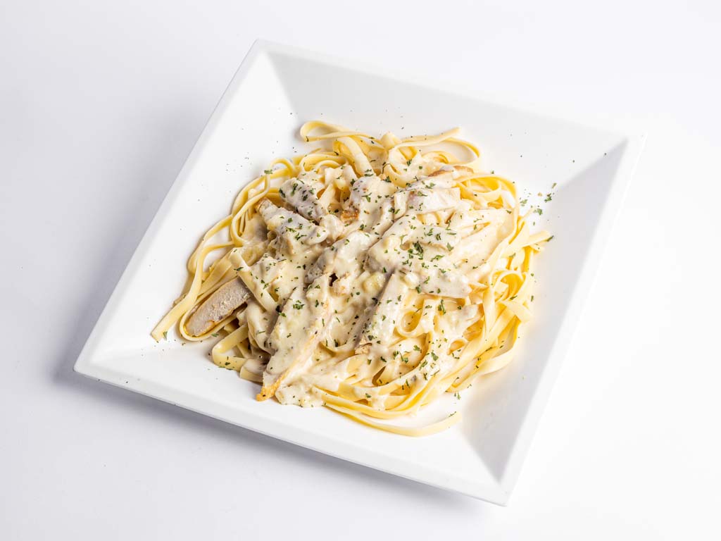 A plate of pasta with chicken and parmesan sauce.