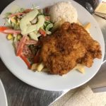 A plate with fried fish and salad on it.
