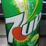 A close-up of a green 7UP soda can displaying the logo and lemon-lime imagery on the front.