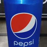 A blue can of Pepsi with the logo prominently displayed on the front, set against a blurred background.