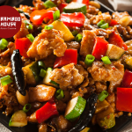 A vibrant stir-fry with chicken, red bell peppers, zucchini, and green onions, garnished with dried chilies. Logo of Bamboo House Asian Cuisine is visible in the corner.