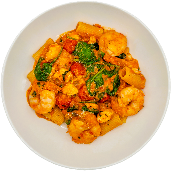 A bowl of pasta with shrimp, spinach, cherry tomatoes, and a creamy tomato sauce.