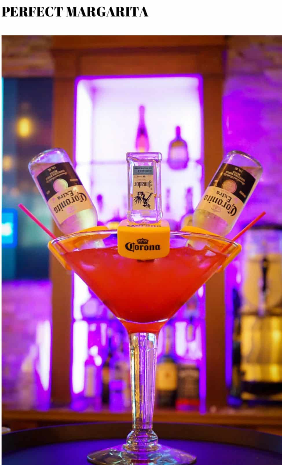 A margarita is sitting on top of a bar.