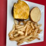 A burger and french fries on a plate.