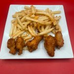 Chicken wings and french fries on a white plate.